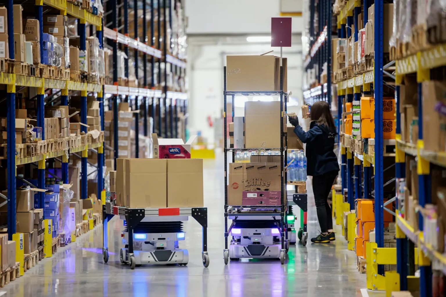 A warehouse associate working safely alongside a Locus Vector autonomous mobile robot