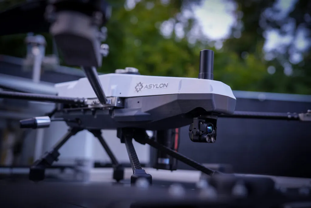 Asylon Guardian security drone with EO/IR camera payload — close-up showing ASYLON branded body and thermal imaging camera