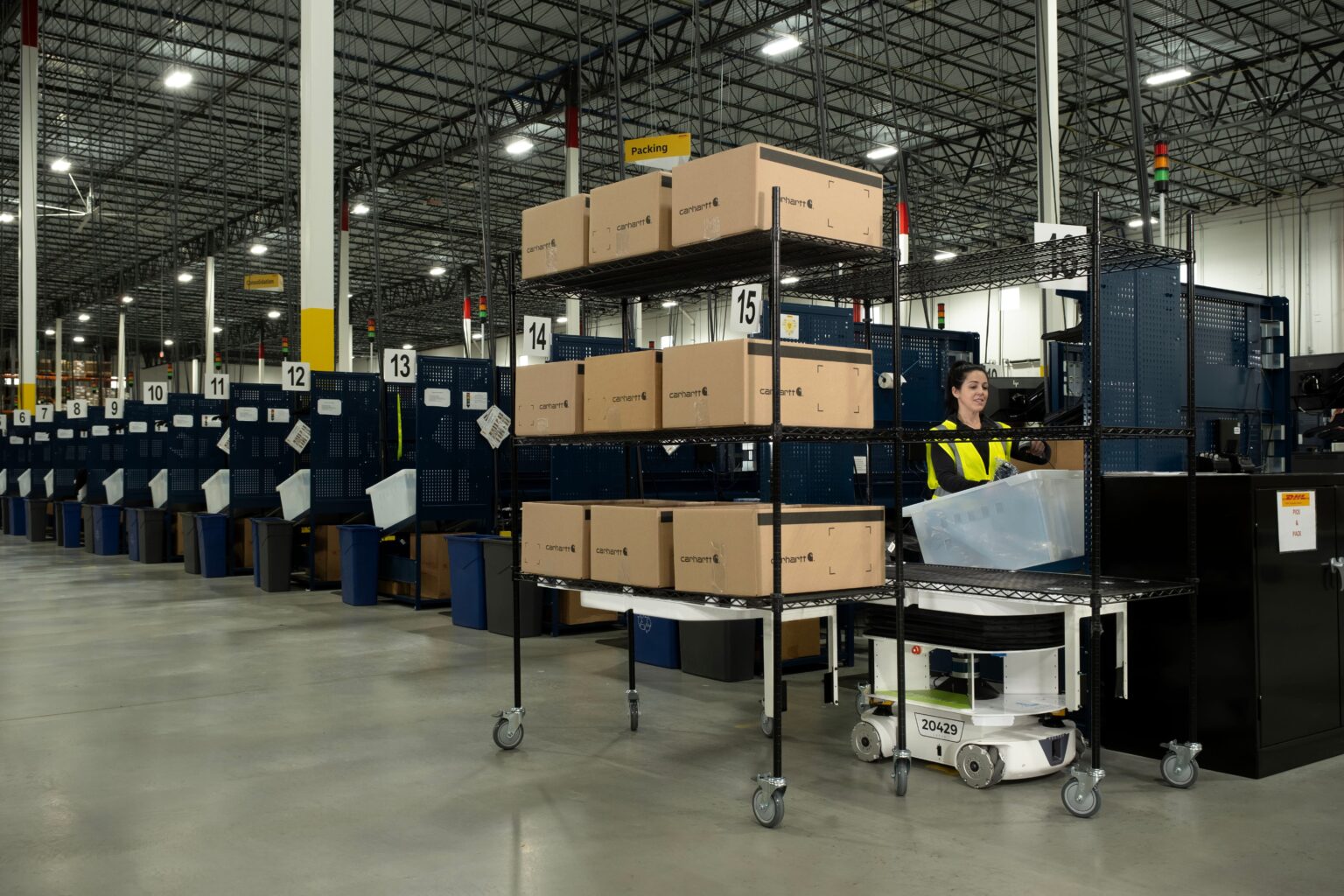 A warehouse associate picking into a Locus autonomous mobile robot to raise picks per hour